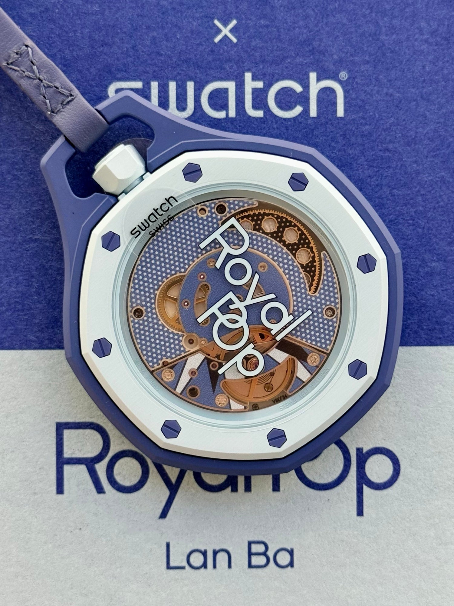 Sapphire exhibition caseback showing the hand-wound Sistem51 movement with Royal Pop print, protective film still applied